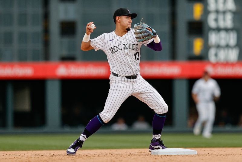 Jun 20, 2024; Denver, Colorado, USA; Colorado Rockies shortstop Alan Trejo (13) fields and throws to first for an out in the ninth inning against the Los Angeles Dodgers at Coors Field. Mandatory Credit: Isaiah J. Downing-USA TODAY Sports