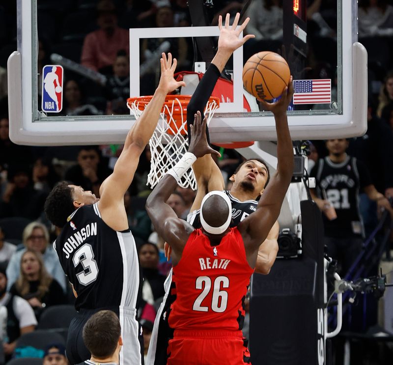 SAN ANTONIO, TX - JANUARY  26:  Victor Wembanyama #1 of the San Antonio Spurs blocks the shot of Duop Reath #26 of the Portland Trail Blazers in the second half at Frost Bank Center on January 26, 2024 in San Antonio, Texas. NOTE TO USER: User expressly acknowledges and agrees that, by downloading and or using this photograph, User is consenting to terms and conditions of the Getty Images License Agreement. (Photo by Ronald Cortes/Getty Images)