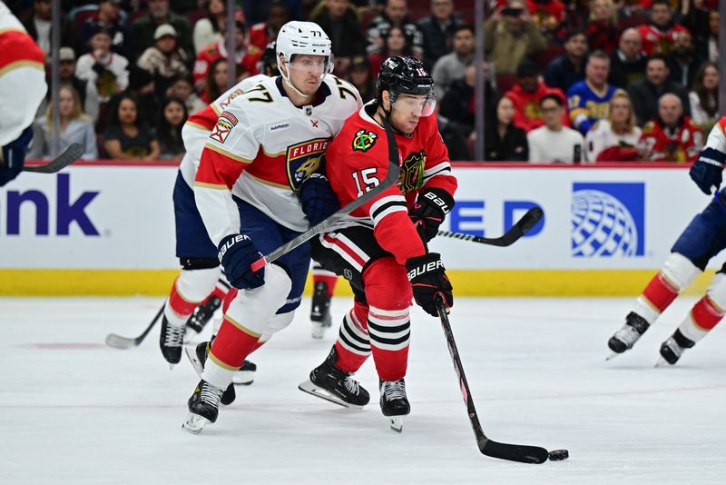 Nov 21, 2024; Chicago, Illinois, USA; Chicago Blackhawks center Craig Smith (15) plays the puck as Florida Panthers defenseman Niko Mikkola (77) defends during the second period at the United Center. Mandatory Credit: Daniel Bartel-Imagn Images