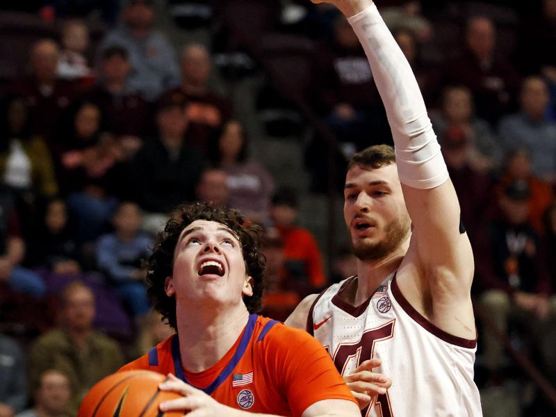 Jan 10, 2024; Blacksburg, Virginia, USA; Clemson Tigers forward Ian Schieffelin (4) drives to the basket against Virginia Tech Hokies forward Robbie Beran (31) during the first half at Cassell Coliseum. Mandatory Credit: Peter Casey-USA TODAY Sports