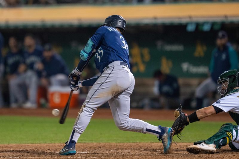 Sep 19, 2023; Oakland, California, USA; XXX at Oakland-Alameda County Seattle Mariners left fielder Dylan Moore (25) hits a RBI double during the seventh inning against the Oakland Athletics. Mandatory Credit: Neville E. Guard-USA TODAY Sports