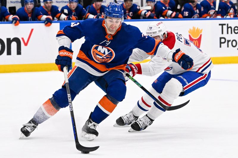 Apr 11, 2024; Elmont, New York, USA; New York Islanders defenseman Adam Pelech (3) skates with the puck chased by Montreal Canadiens left wing Tanner Pearson (70) during the first period at UBS Arena. Mandatory Credit: Dennis Schneidler-USA TODAY Sports