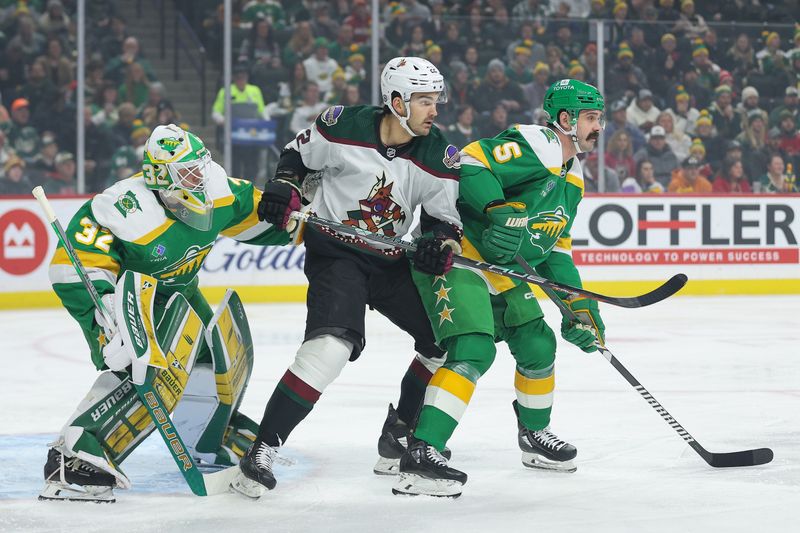 Jan 13, 2024; Saint Paul, Minnesota, USA; Minnesota Wild defenseman Jake Middleton (5) and Arizona Coyotes center Jack McBain (22) compete for position as goaltender Filip Gustavsson (32) defends his net during the first period at Xcel Energy Center. Mandatory Credit: Matt Krohn-USA TODAY Sports