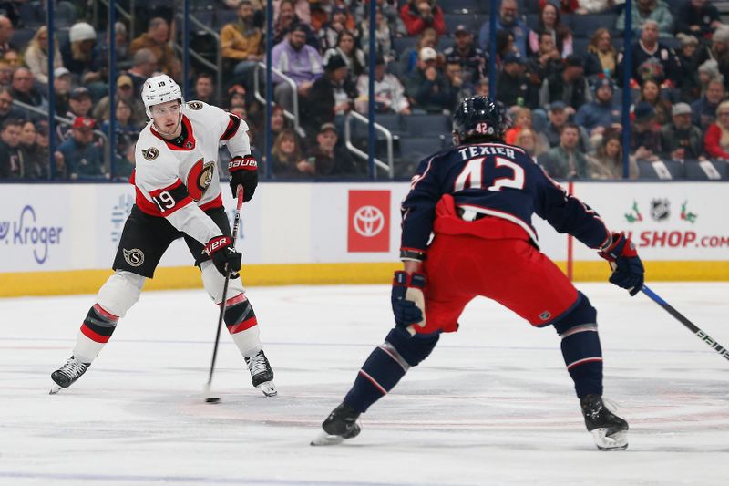 Dec 1, 2023; Columbus, Ohio, USA; Ottawa Senators right wing Drake Batherson (19) passes the puck as Columbus Blue Jackets center Alexander Texier (42) defends during the first period at Nationwide Arena. Mandatory Credit: Russell LaBounty-USA TODAY Sports