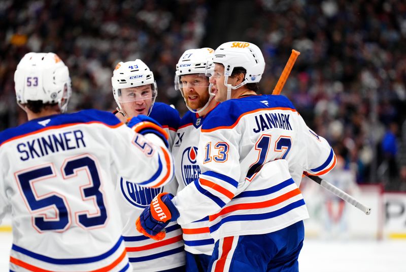 Nov 30, 2024; Denver, Colorado, USA; Edmonton Oilers defenseman Brett Kulak (27) celebrates his third period goal with defenseman Ty Emberson (49) and center Jeff Skinner (53) and center Mattias Janmark (13) against the Colorado Avalanche  at Ball Arena. Mandatory Credit: Ron Chenoy-Imagn Images