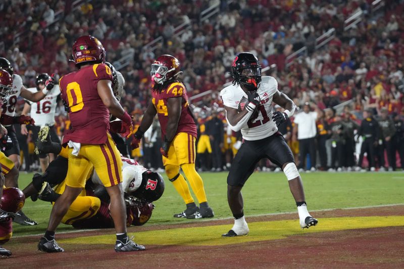 Oct 25, 2024; Los Angeles, California, USA; Rutgers Scarlet Knights running back Antwan Raymond (21) scores a 3-yard touchdown run against the Southern California Trojans in the first half at United Airlines Field at Los Angeles Memorial Coliseum. Mandatory Credit: Kirby Lee-Imagn Images