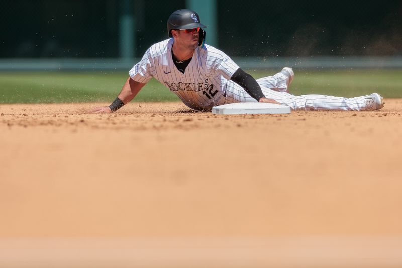 Jun 5, 2024; Denver, Colorado, USA; Colorado Rockies outfielder Sean Bouchard (12) slides safely into second during the fourth inning against the Cincinnati Reds at Coors Field. Mandatory Credit: Andrew Wevers-USA TODAY Sports