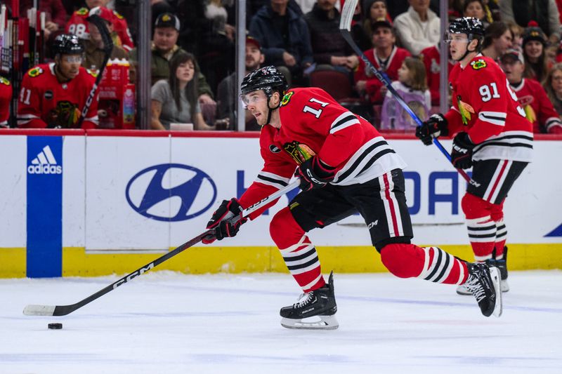 Dec 10, 2023; Chicago, Illinois, USA; Chicago Blackhawks right wing Taylor Raddysh (11) skates with the puck against the Washington Capitals during the first period at the United Center. Mandatory Credit: Daniel Bartel-USA TODAY Sports