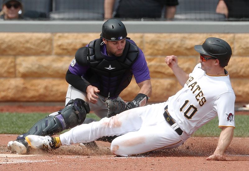 May 10, 2023; Pittsburgh, Pennsylvania, USA;  Colorado Rockies catcher Austin Wynns (16) tags Pittsburgh Pirates left fielder Bryan Reynolds (10) out at home plate attempting to score during the sixth inning at PNC Park. Mandatory Credit: Charles LeClaire-USA TODAY Sports