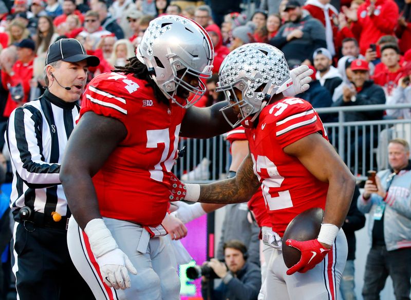 Nov 18, 2023; Columbus, Ohio, USA;  Ohio State Buckeyes running back TreVeyon Henderson (32) celebrates his touchdown run with offensive lineman Donovan Jackson (74) during the first quarter against the Minnesota Golden Gophers at Ohio Stadium. Mandatory Credit: Joseph Maiorana-USA TODAY Sports