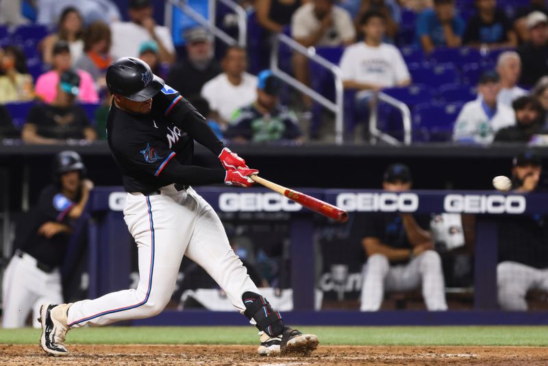 Jul 19, 2024; Miami, Florida, USA; Miami Marlins catcher Nick Fortes (4) hits a single against the New York Mets during the fourth inning at loanDepot Park. Mandatory Credit: Sam Navarro-USA TODAY Sports