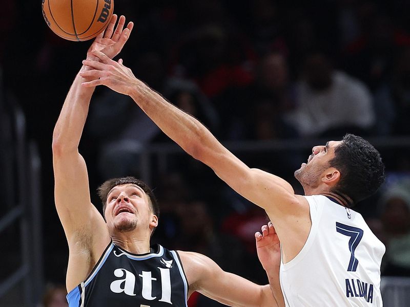 ATLANTA, GEORGIA - DECEMBER 23:  Bogdan Bogdanovic #13 of the Atlanta Hawks battles for a rebound against Santi Aldama #7 of the Memphis Grizzlies during the second quarter at State Farm Arena on December 23, 2023 in Atlanta, Georgia.  NOTE TO USER: User expressly acknowledges and agrees that, by downloading and/or using this photograph, user is consenting to the terms and conditions of the Getty Images License Agreement. (Photo by Kevin C. Cox/Getty Images)