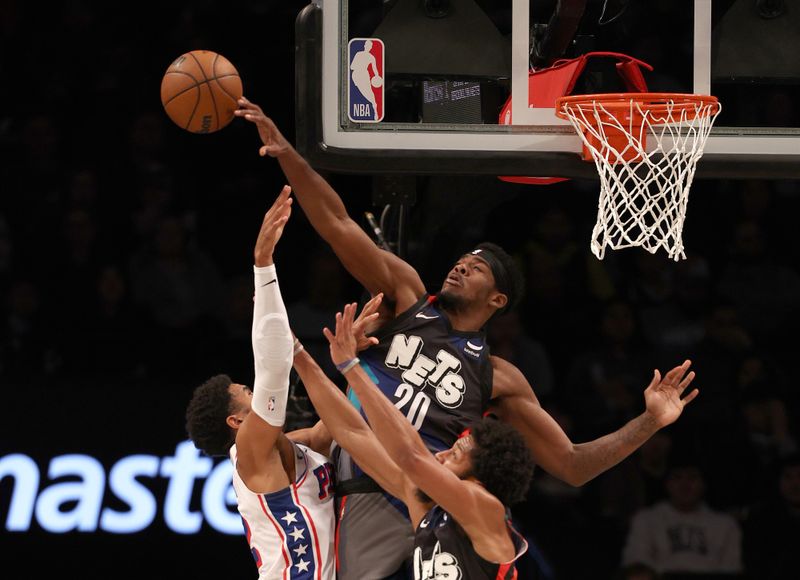 NEW YORK, NEW YORK - NOVEMBER 19:  Royce O'Neale #00 of the Brooklyn Nets blocks a shot by Tobias Harris #12 of the Philadelphia 76ers as Spencer Dinwiddie #26 of the Brooklyn Nets defends in the first half at Barclays Center on November 19, 2023 in the Brooklyn borough of New York City. NOTE TO USER: User expressly acknowledges and agrees that, by downloading and or using this photograph, User is consenting to the terms and conditions of the Getty Images License Agreement. (Photo by Elsa/Getty Images)