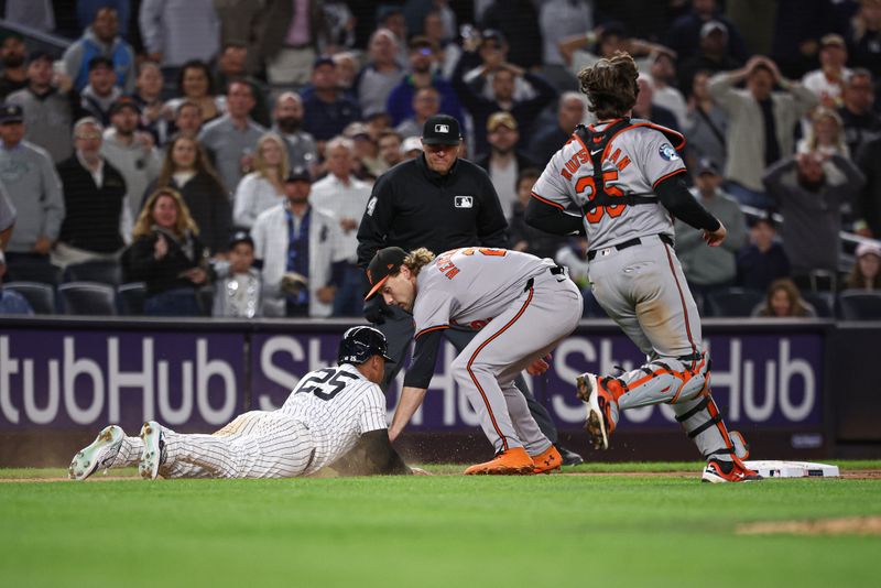 Sep 24, 2024; Bronx, New York, USA; New York Yankees second baseman Gleyber Torres (25) is tagged out after being caught in a run down by Baltimore Orioles shortstop Gunnar Henderson (2) during the seventh inning at Yankee Stadium. Mandatory Credit: Vincent Carchietta-Imagn Images