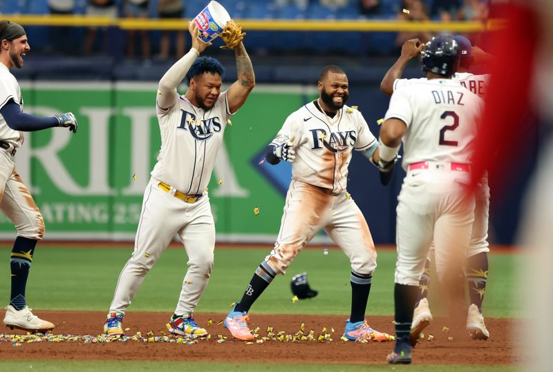 Sep 21, 2023; St. Petersburg, Florida, USA; Tampa Bay Rays center fielder Manuel Margot (13) is congratulated after he hit the game winning walk off RBI during the ninth inning against the Los Angeles Angels at Tropicana Field. Mandatory Credit: Kim Klement Neitzel-USA TODAY Sports