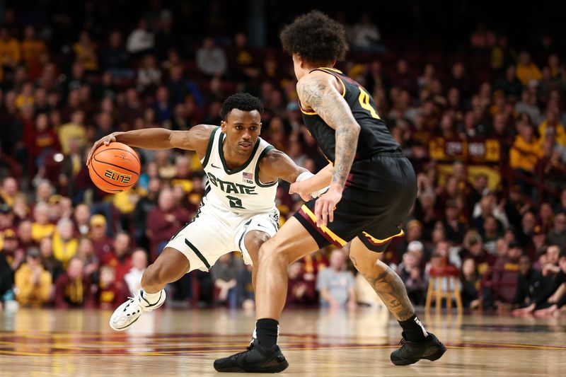 Feb 6, 2024; Minneapolis, Minnesota, USA; Michigan State Spartans guard Tyson Walker (2) dribbles as Minnesota Golden Gophers guard Braeden Carrington (4) defends during the second half at Williams Arena. Mandatory Credit: Matt Krohn-USA TODAY Sports