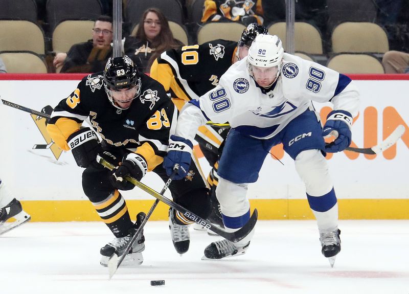 Nov 19, 2024; Pittsburgh, Pennsylvania, USA; Pittsburgh Penguins left wing Matt Nieto (83) and Tampa Bay Lightning defenseman J.J. Moser (90) chase the puck during the third period at PPG Paints Arena. Mandatory Credit: Charles LeClaire-Imagn Images