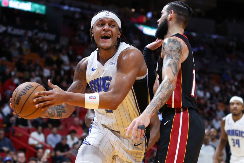 MIAMI, FLORIDA - FEBRUARY 06: Paolo Banchero #5 of the Orlando Magic drives against Caleb Martin #16 of the Miami Heat during the first quarter of the game at Kaseya Center on February 06, 2024 in Miami, Florida. NOTE TO USER: User expressly acknowledges and agrees that, by downloading and or using this photograph, User is consenting to the terms and conditions of the Getty Images License Agreement. (Photo by Megan Briggs/Getty Images)