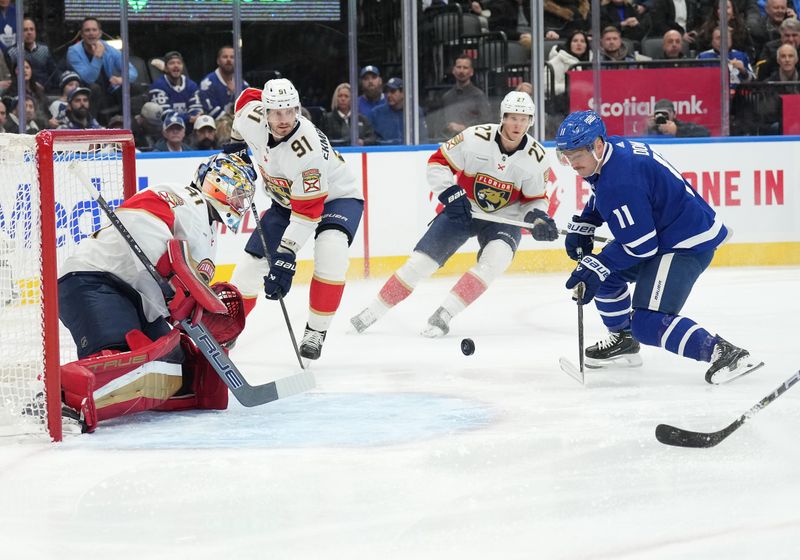 Nov 28, 2023; Toronto, Ontario, CAN; Toronto Maple Leafs center Max Domi (11) battles for the puck in front of Florida Panthers goaltender Anthony Stolarz (41) during the first period at Scotiabank Arena. Mandatory Credit: Nick Turchiaro-USA TODAY Sports