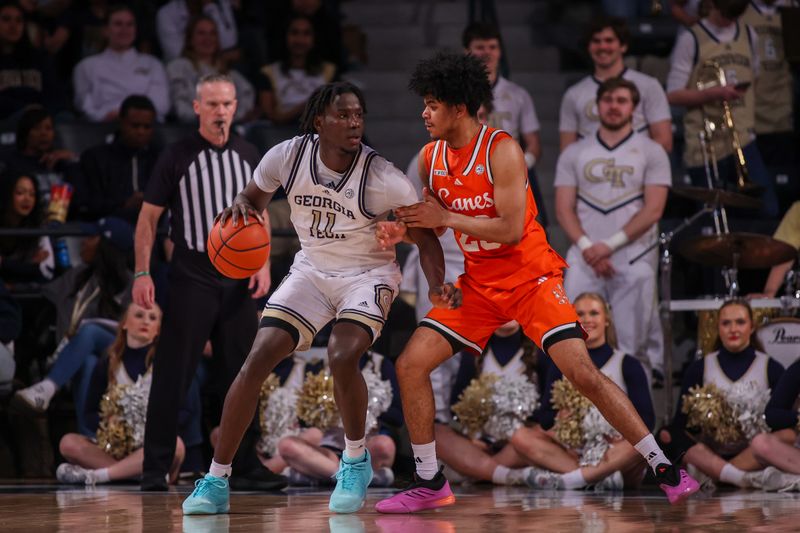 Mar 4, 2025; Atlanta, Georgia, USA; Georgia Tech Yellow Jackets forward Baye Ndongo (11) is defended by Miami Hurricanes guard Austin Swartz (23) in the first half at McCamish Pavilion. Mandatory Credit: Brett Davis-Imagn Images