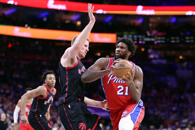 PHILADELPHIA, PENNSYLVANIA - DECEMBER 22: Joel Embiid #21 of the Philadelphia 76ers drives as Jakob Poeltl #19 of the Toronto Raptors guards during the third quarter at the Wells Fargo Center on December 22, 2023 in Philadelphia, Pennsylvania. NOTE TO USER: User expressly acknowledges and agrees that, by downloading and or using this photograph, User is consenting to the terms and conditions of the Getty Images License Agreement. (Photo by Tim Nwachukwu/Getty Images)