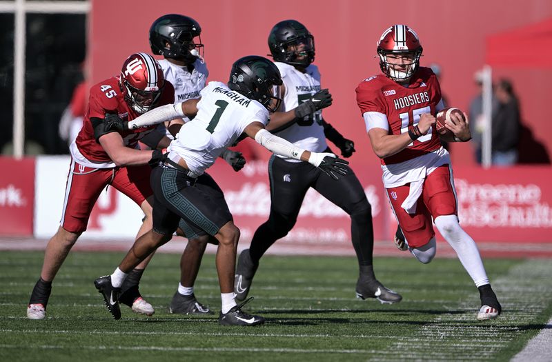 Nov 18, 2023; Bloomington, Indiana, USA; Indiana Hoosiers quarterback Brendan Sorsby (15) runs the ball out of bounds in front of Michigan State Spartans defensive back Jaden Mangham (1) during the second half at Memorial Stadium. Mandatory Credit: Marc Lebryk-USA TODAY Sports