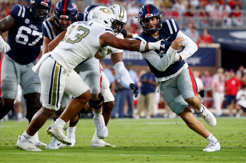 Sep 16, 2023; Oxford, Mississippi, USA; Mississippi Rebels quarterback Jaxson Dart (2) runs the ball as Georgia Tech Yellow Jackets linebacker Paul Moala (13) attempts to make the tackle during the first half at Vaught-Hemingway Stadium. Mandatory Credit: Petre Thomas-USA TODAY Sports