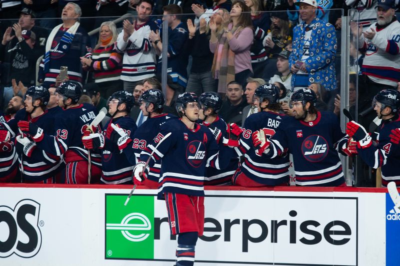 Feb 10, 2024; Winnipeg, Manitoba, CAN;  Winnipeg Jets forward Mark Scheifele (55) celebrates with teammates after scoring a goal against the Pittsburgh Penguins during the first period at Canada Life Centre. Mandatory Credit: Terrence Lee-USA TODAY Sports