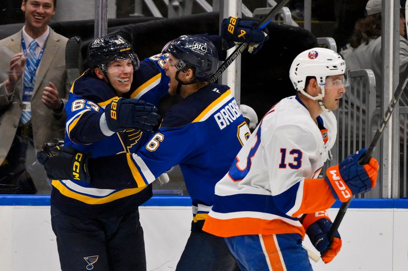 Oct 17, 2024; St. Louis, Missouri, USA;  St. Louis Blues left wing Jake Neighbours (63) celebrates with defenseman Philip Broberg (6) after scoring the game winning goal against New York Islanders goaltender Ilya Sorokin (not pictured) in overtime at Enterprise Center. Mandatory Credit: Jeff Curry-Imagn Images