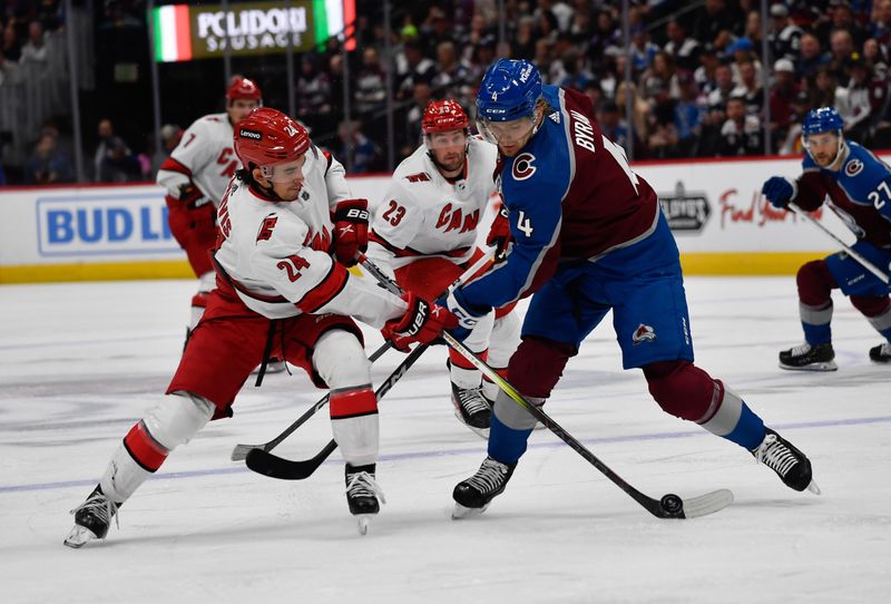 Oct 21, 2023; Denver, Colorado, USA; Carolina Hurricanes center Seth Jarvis (24) gains control of the puck away from Colorado Avalanche defenseman Bowen Byram (4) in the first period at Ball Arena. Mandatory Credit: John Leyba-USA TODAY Sports