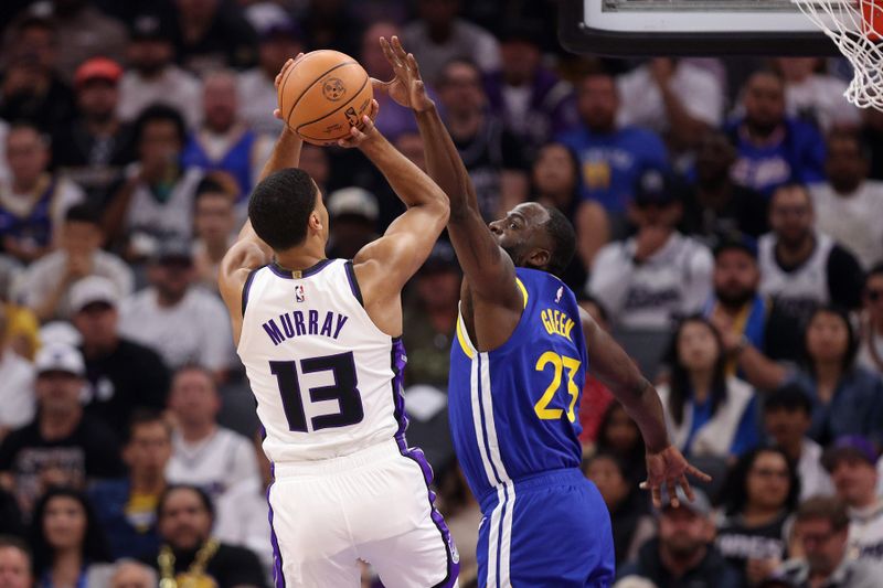 SACRAMENTO, CALIFORNIA - APRIL 16: Keegan Murray #13 of the Sacramento Kings shoots over Draymond Green #23 of the Golden State Warriors in the first quarter during the Play-In Tournament at Golden 1 Center on April 16, 2024 in Sacramento, California.  NOTE TO USER: User expressly acknowledges and agrees that, by downloading and or using this photograph, User is consenting to the terms and conditions of the Getty Images License Agreement.  (Photo by Ezra Shaw/Getty Images)