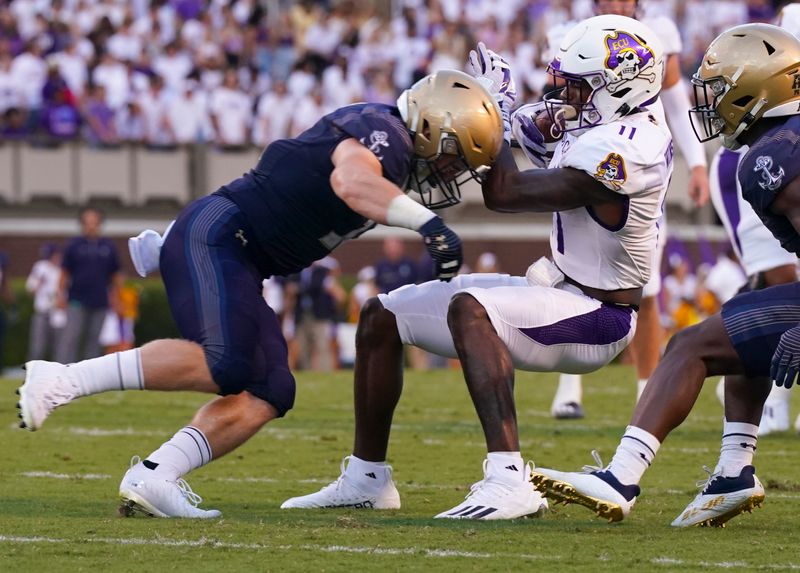 Sep 24, 2022; Greenville, North Carolina, USA; East Carolina Pirates wide receiver Isaiah Winstead (11) is hit after a catch against Navy Midshipmen linebacker Eavan Gibbons (11) during the first half at Dowdy-Ficklen Stadium. Mandatory Credit: James Guillory-USA TODAY Sports