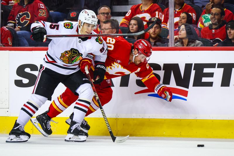 Oct 15, 2024; Calgary, Alberta, CAN; Calgary Flames center Blake Coleman (20) and Chicago Blackhawks right wing Ilya Mikheyev (95) battles for the puck during the third period at Scotiabank Saddledome. Mandatory Credit: Sergei Belski-Imagn Images