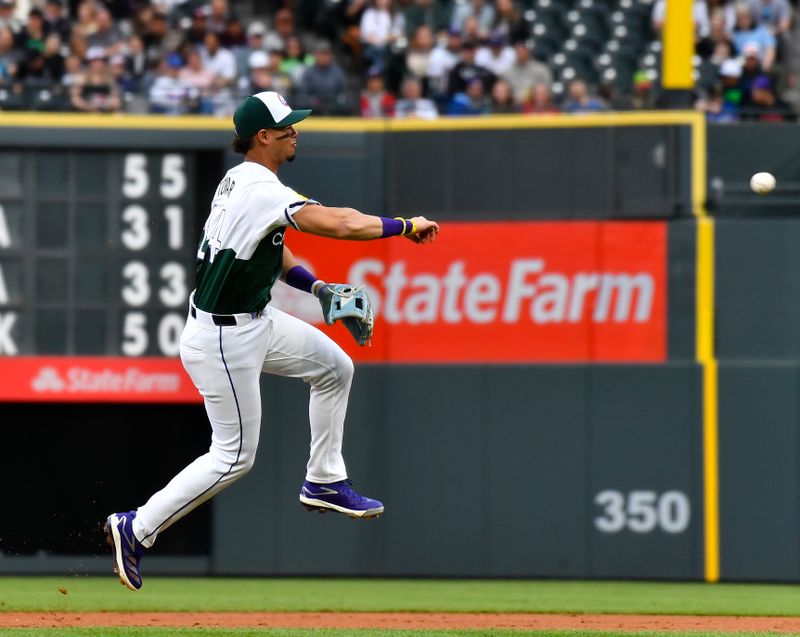 May 11, 2024; Denver, Colorado, USA; Colorado Rockies shortstop Ezequiel Tovar (14) makes a throw to retire a runner at first base against the Texas Rangers during the third inning at Coors Field. Mandatory Credit: John Leyba-USA TODAY Sports