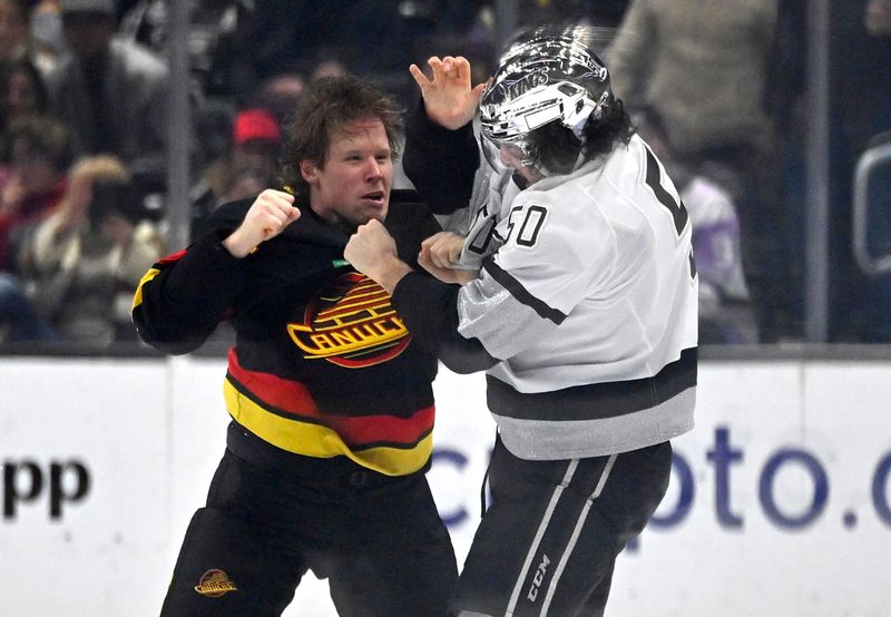 Apr 10, 2023; Los Angeles, California, USA;  Vancouver Canucks center Sheldon Dries (15) and Los Angeles Kings defenseman Sean Durzi (50) fight in the second period at Crypto.com Arena. Mandatory Credit: Jayne Kamin-Oncea-USA TODAY Sports