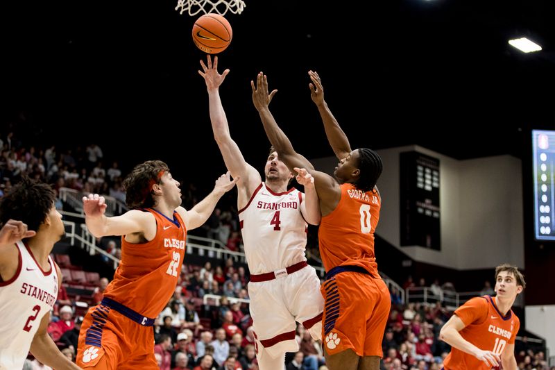 Feb 4, 2026; Stanford, California, USA; Stanford Cardinal forward AJ Rohosy (4) shoots against Clemson Tigers center Carter Welling (22) and forward RJ Godfrey (0) during the first half at Maples Pavilion. Mandatory Credit: John Hefti-Imagn Images
