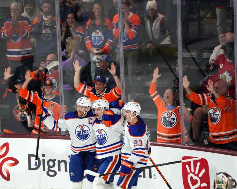 Feb 19, 2024; Tempe, Arizona, USA; Edmonton Oilers left wing Zach Hyman (18) celebrates his goal with Edmonton Oilers center Connor McDavid (97) and Edmonton Oilers center Ryan Nugent-Hopkins (93) against the Arizona Coyotes  during the third period at Mullett Arena. Mandatory Credit: Joe Camporeale-USA TODAY Sports