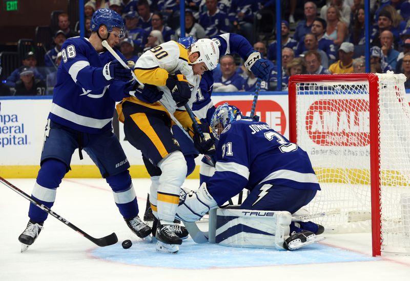 Oct 10, 2023; Tampa, Florida, USA; Tampa Bay Lightning goaltender Jonas Johansson (31) defends Nashville Predators center Ryan O'Reilly (90) during the second period at Amalie Arena. Mandatory Credit: Kim Klement Neitzel-USA TODAY Sports