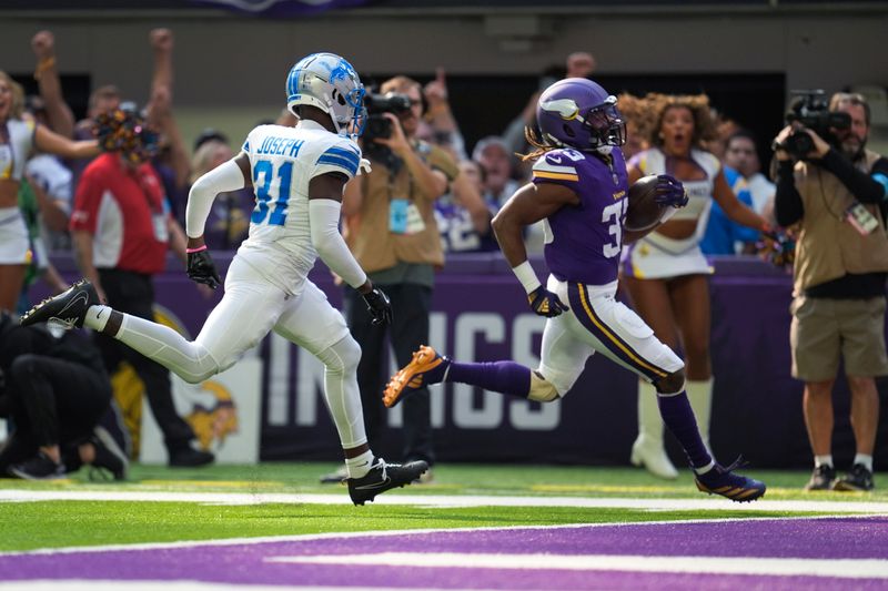 Minnesota Vikings running back Aaron Jones runs past Detroit Lions safety Kerby Joseph (31) for a 34-yard touchdown in the first half of an NFL football game Sunday, Oct. 20, 2024, in Minneapolis. (AP Photo/Abbie Parr)