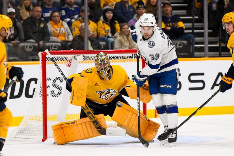 Nov 29, 2024; Nashville, Tennessee, USA;  Nashville Predators goaltender Juuse Saros (74) blocks the deflection from Tampa Bay Lightning left wing Brandon Hagel (38) during the first period at Bridgestone Arena. Mandatory Credit: Steve Roberts-Imagn Images