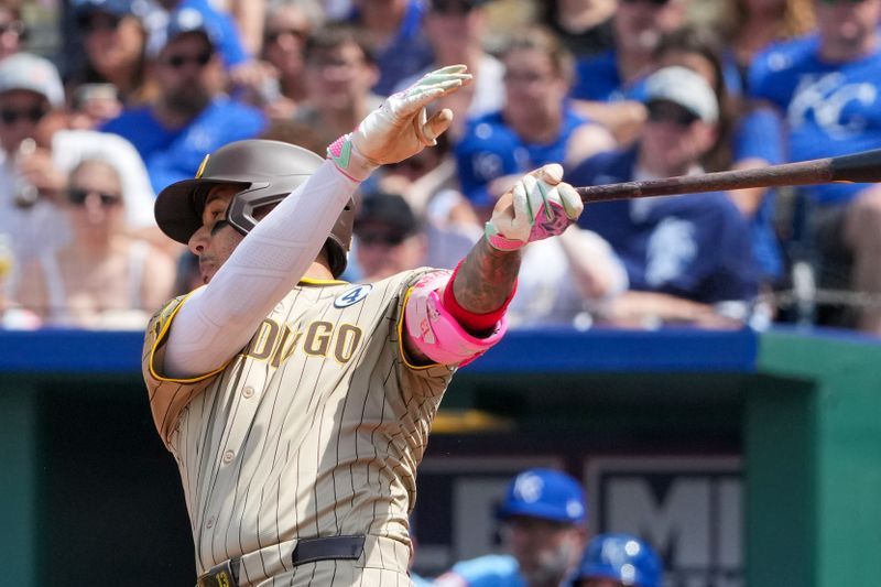 Jun 2, 2024; Kansas City, Missouri, USA; San Diego Padres designated hitter Manny Machado (13) hits a one run single against the Kansas City Royals in the eighth inning at Kauffman Stadium. Mandatory Credit: Denny Medley-USA TODAY Sports