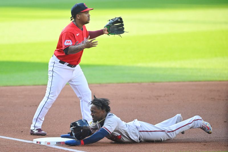 Jul 5, 2023; Cleveland, Ohio, USA; Atlanta Braves second baseman Ozzie Albies (1) slides safely to third base beside Cleveland Guardians third baseman Jose Ramirez (11) in the first inning at Progressive Field. Mandatory Credit: David Richard-USA TODAY Sports