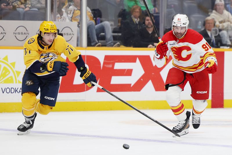 Nov 1, 2025; Nashville, Tennessee, USA; Nashville Predators right wing Matthew Wood (71) and Calgary Flames center Nazem Kadri (91) chase after the puck during the third period at Bridgestone Arena. Mandatory Credit: Alan Poizner-Imagn Images