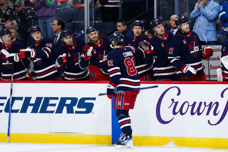 Oct 18, 2024; Winnipeg, Manitoba, CAN;  Winnipeg Jets forward Kyle Connor (81) is congratulated by his team mates on his goal against the San Jose Sharks during the second period at Canada Life Centre. Mandatory Credit: Terrence Lee-Imagn Images