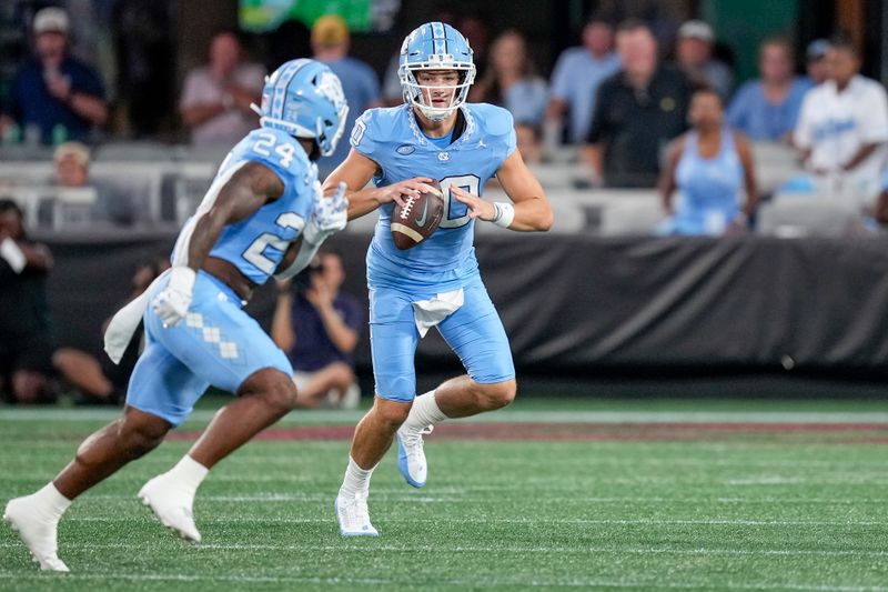 Sep 2, 2023; Charlotte, North Carolina, USA; North Carolina Tar Heels quarterback Drake Maye (10) looks to pass to running back British Brooks (24) during the first quarter against the South Carolina Gamecocks at Bank of America Stadium. Mandatory Credit: Jim Dedmon-USA TODAY Sports