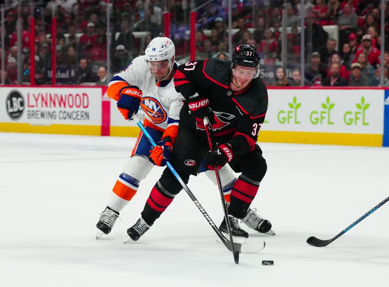 Apr 30, 2024; Raleigh, North Carolina, USA; Carolina Hurricanes right wing Andrei Svechnikov (37) skates with the puck against New York Islanders center Bo Horvat (14) during the first period in game five of the first round of the 2024 Stanley Cup Playoffs at PNC Arena. Mandatory Credit: James Guillory-USA TODAY Sports