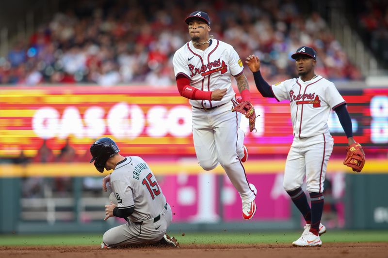 Apr 6, 2024; Atlanta, Georgia, USA; Atlanta Braves shortstop Orlando Arcia (11) attempts to turn a double play over Arizona Diamondbacks right fielder Randal Grichuk (15) as second baseman Ozzie Albies (1) looks on in the first inning at Truist Park. Mandatory Credit: Brett Davis-USA TODAY Sports