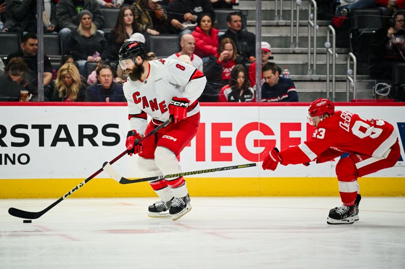 Apr 4, 2025; Detroit, Michigan, USA; Carolina Hurricanes defenseman Brent Burns (8) brings the puck up ice against Detroit Red Wings right wing Alex DeBrincat (93) during the game at Little Caesars Arena. Mandatory Credit: Tim Fuller-Imagn Images
