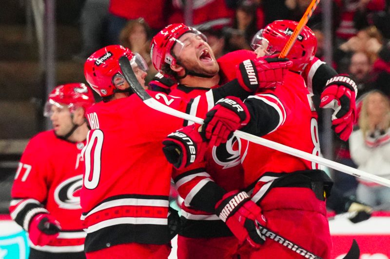 Oct 26, 2023; Raleigh, North Carolina, USA; Carolina Hurricanes center Martin Necas (88) celebrates his game winning goal with left wing Brendan Lemieux (28) and  center Sebastian Aho (20) against the Seattle Kraken  in the overtime at PNC Arena. Mandatory Credit: James Guillory-USA TODAY Sports