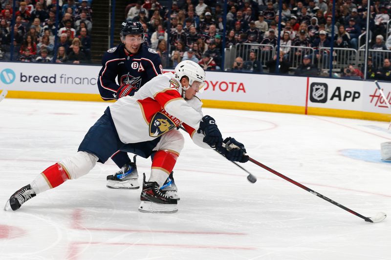 Oct 15, 2024; Columbus, Ohio, USA; Florida Panthers center Anton Lundell (15) carries the puck past Columbus Blue Jackets defenseman Zach Werenski (8) during the third period at Nationwide Arena. Mandatory Credit: Russell LaBounty-Imagn Images